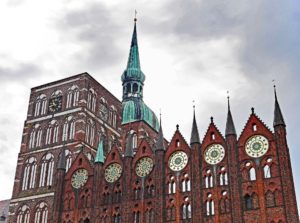 Die Fassade des Stralsunder Rathauses vor den Doppeltürmen der Nikolaikirche 